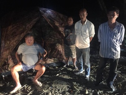 "Premchai Karnasuta, far left, sits in the campsite where he was found with the remains of a leopard, panther and other wildlife Monday in the Thungyai Naresuan Wildlife Sanctuary in Kanchanaburi province" (Photo: khaosodenglish.com).